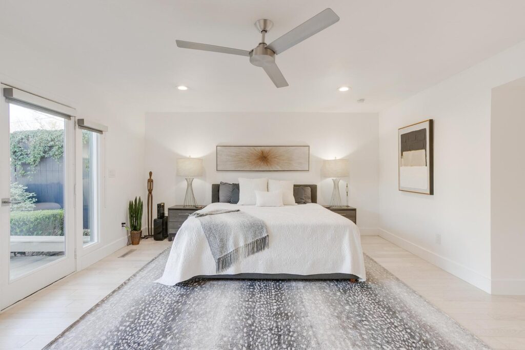 The bright primary bedroom boasts French doors and automatic shades.