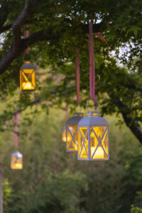 Beds – Lanterns dangle from the trees at Party in the Garden. (Photo by Sharon Ellman)